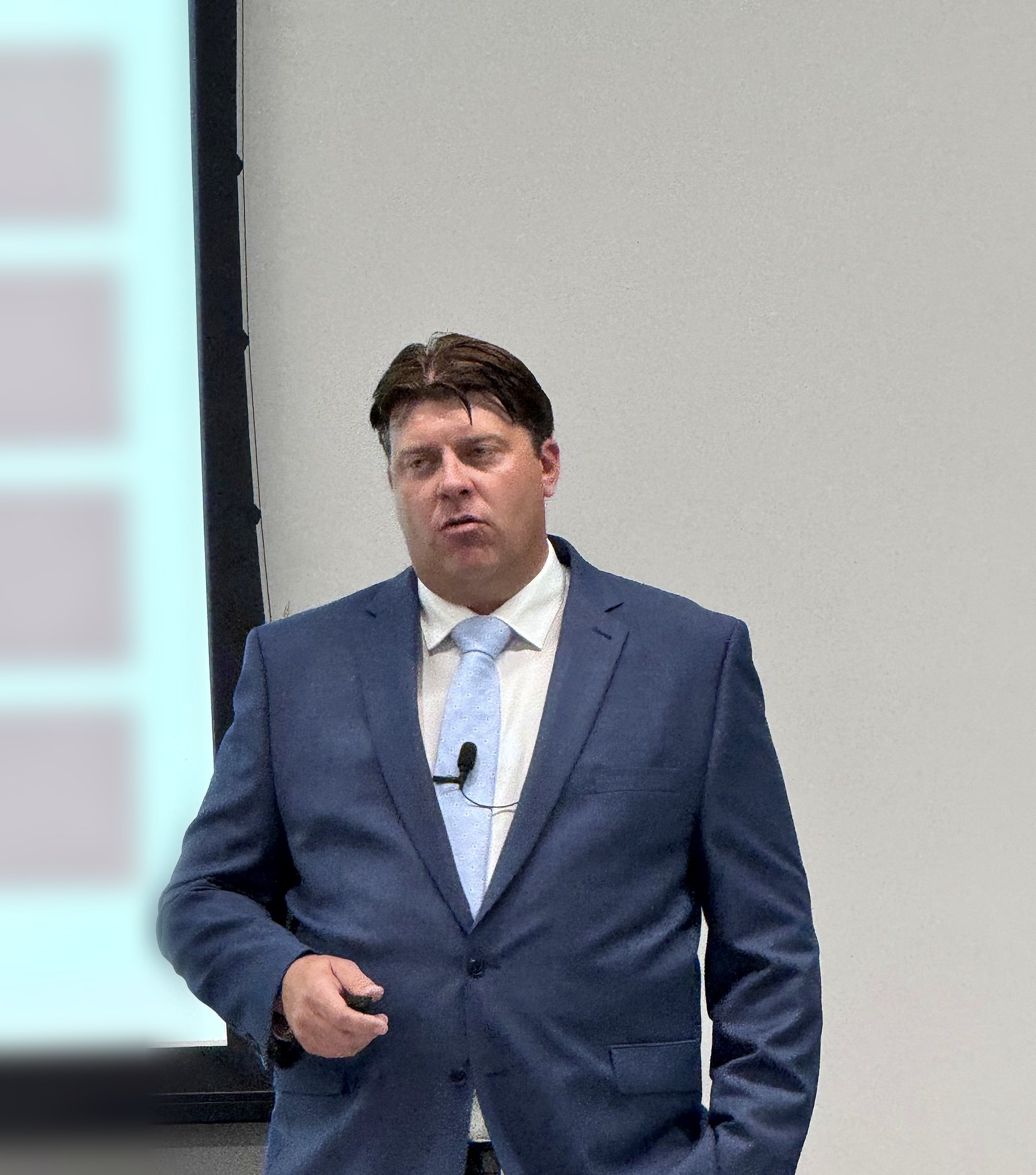 Bill presenting at a retirement education seminar, mid-speech with clicker